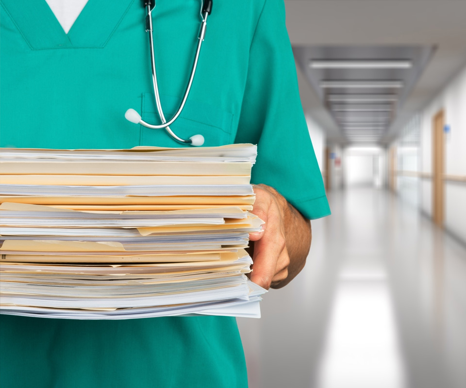 doctor holding pile of documents