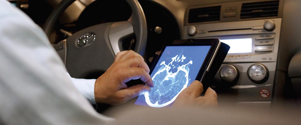 doctor reviewing an x-ray image on his iPad in his car