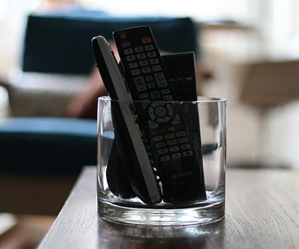 several remote controls in a glass